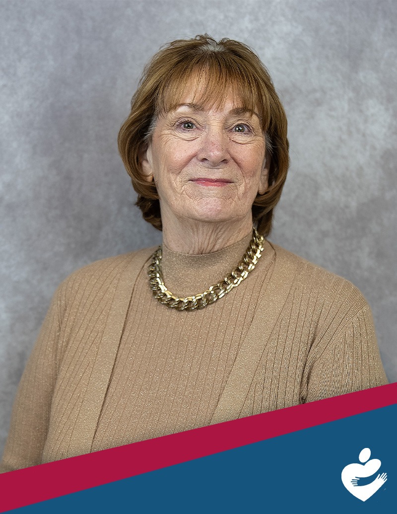 Donna Tooley, CFO Interim with red and blue banner and heart logo at the right corner